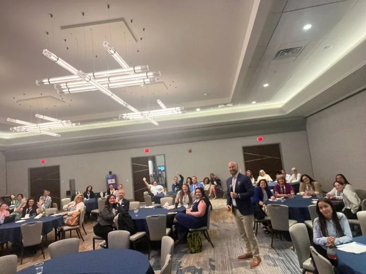 Chris Gloede presenting to a ballroom of attendees seated at round tables at AICPA Interchange.