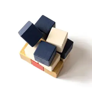 Navy, cream and gold building blocks being stacked.