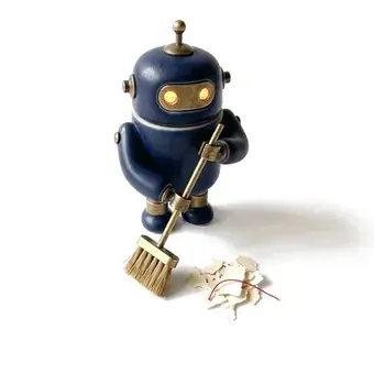 A small navy robot sweeping paper scraps into a pile.