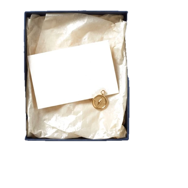 An open gift box with a welcome card and a gold pin.