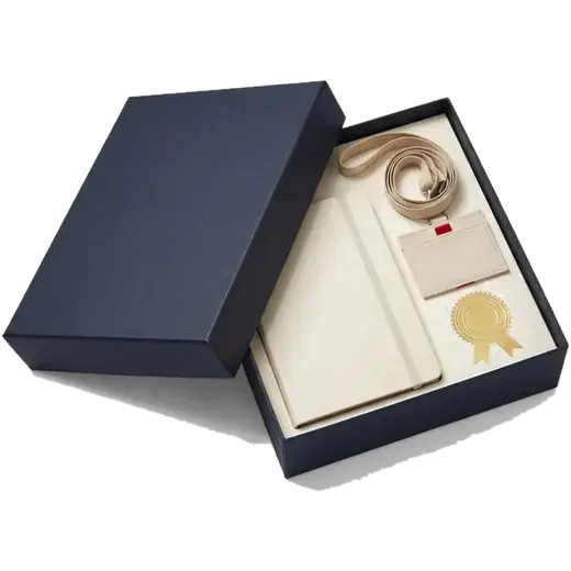 An open navy gift box holding a conference badge, a journal and a gold certificate seal.